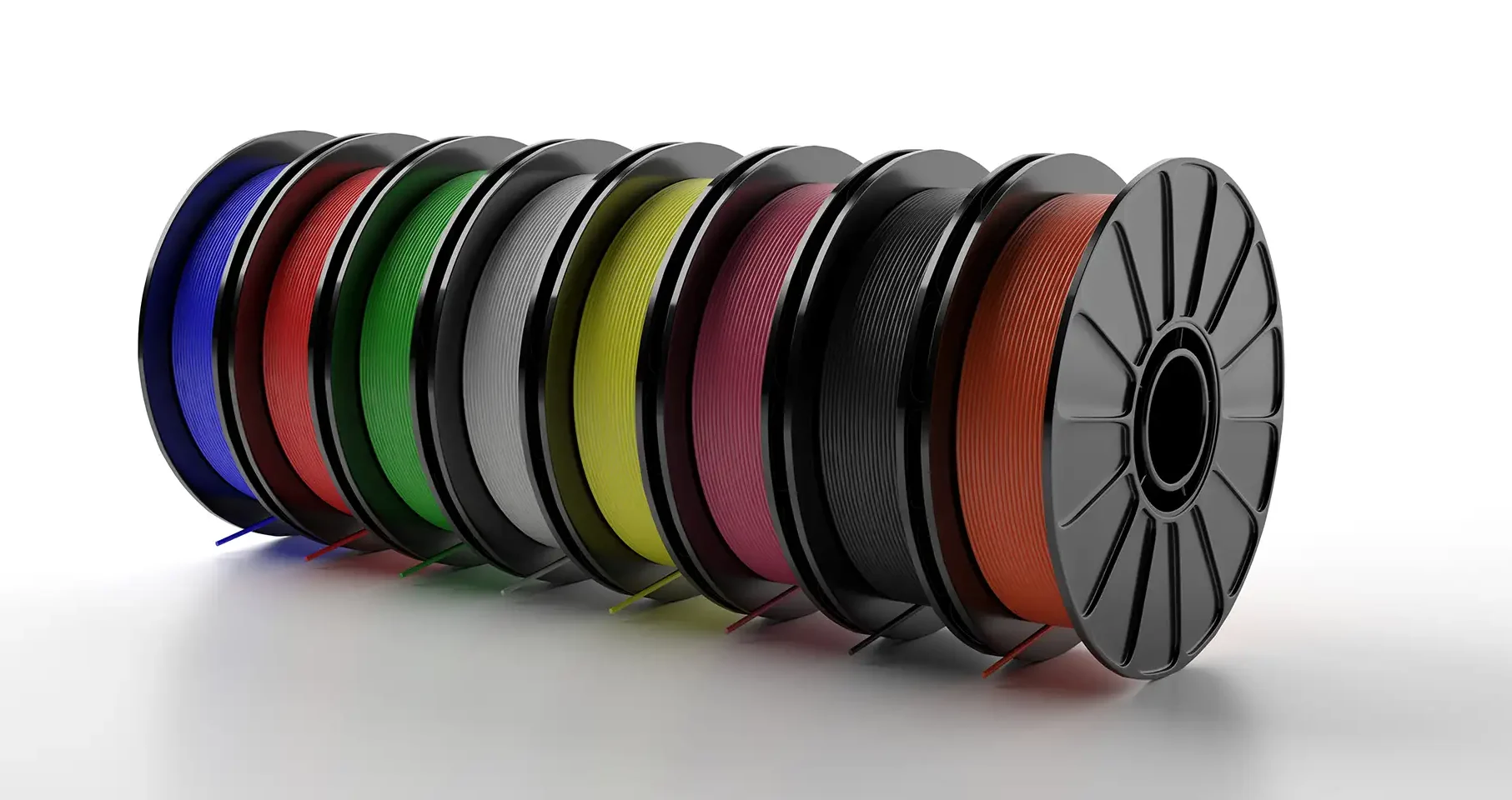 Colorful 3D printer filament spools on white surface showing PLA color range