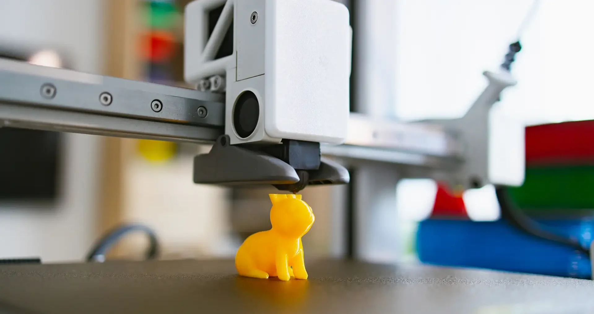 3D printer creating a detailed yellow cat figurine showing a quality finished print result