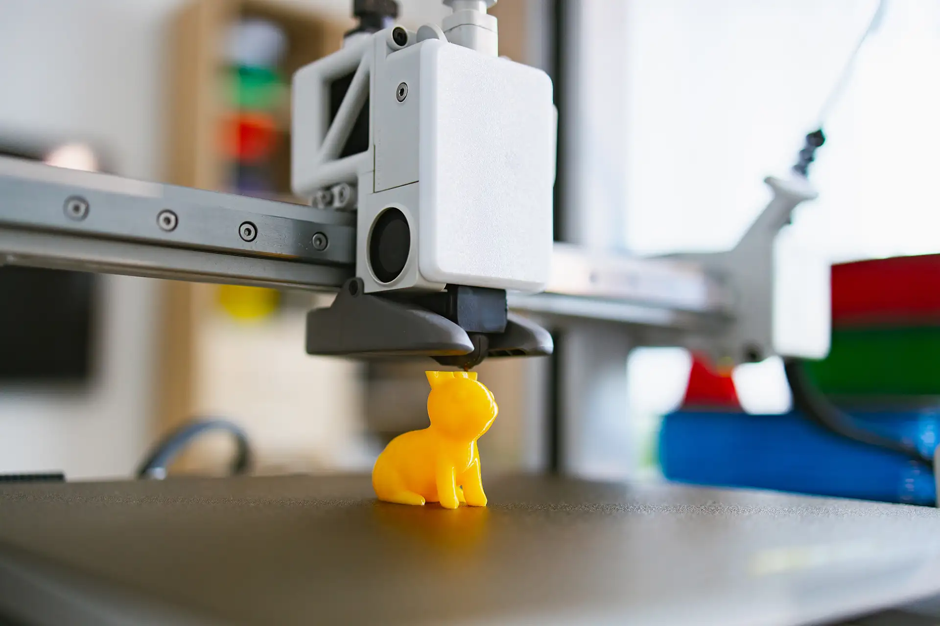 3D Printed Yellow Cat Figurine Quality Result 3D printer creating a detailed yellow cat figurine showing a quality finished print result