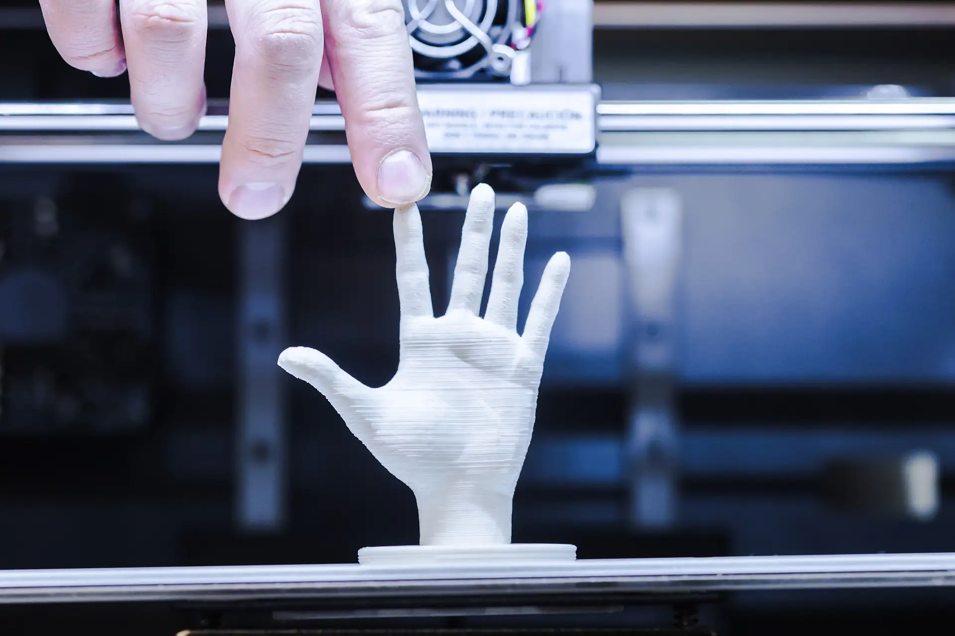 Close-up of 3D printed hand model showing layer line errors and surface imperfections from FDM printing