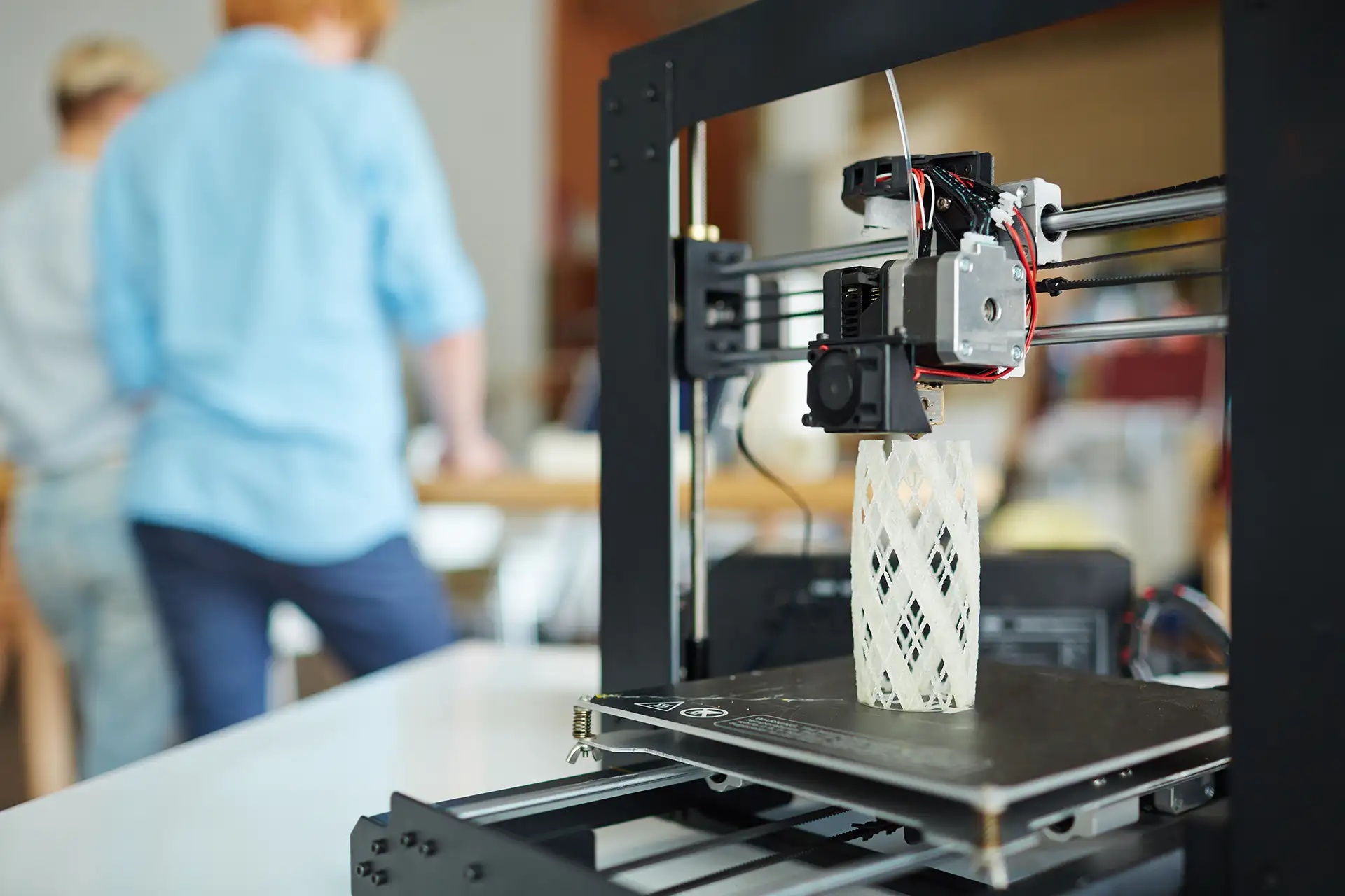 FDM 3D printer creating a complex object layer by layer in a maker workspace