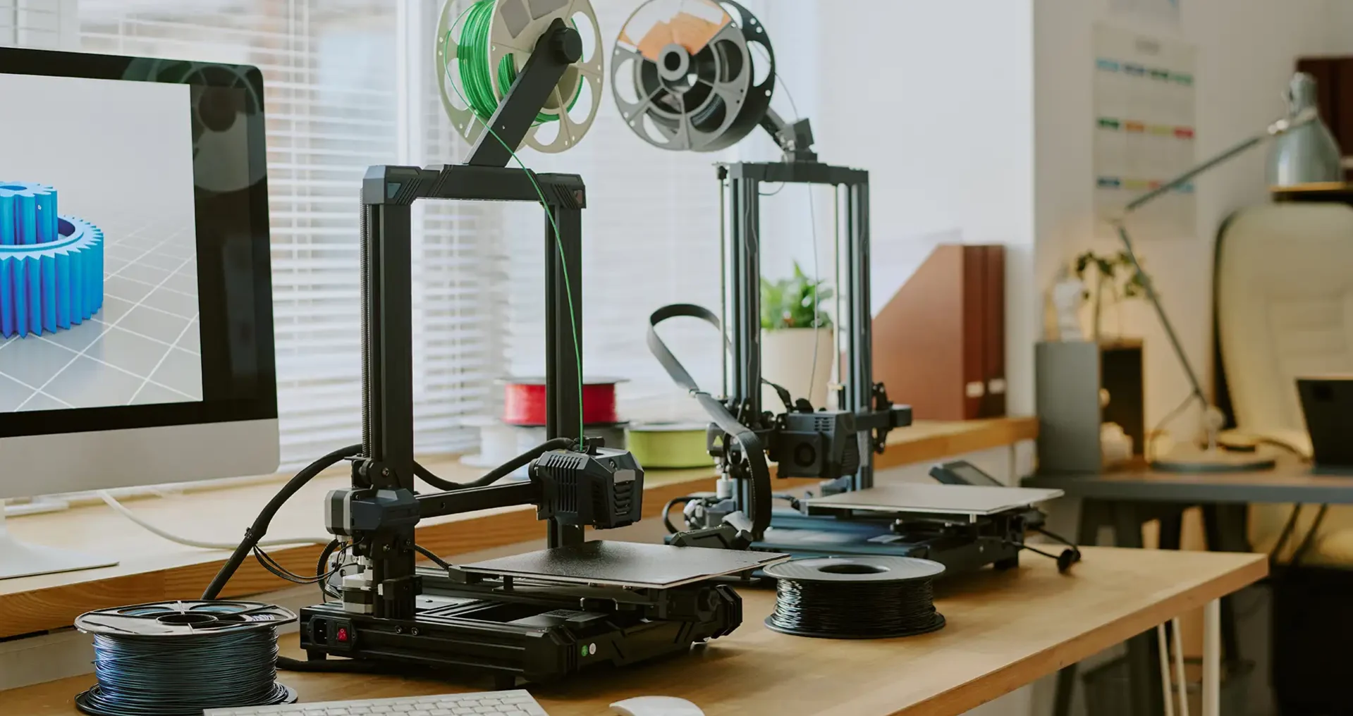 FDM 3D printing machines on office desk near computer FDM 3D printing machines on office desk near computer workstation